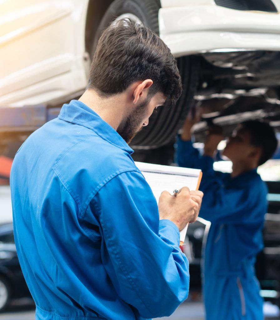 Auto mechanic writing on a checklist - Car Servicing Prudhoe